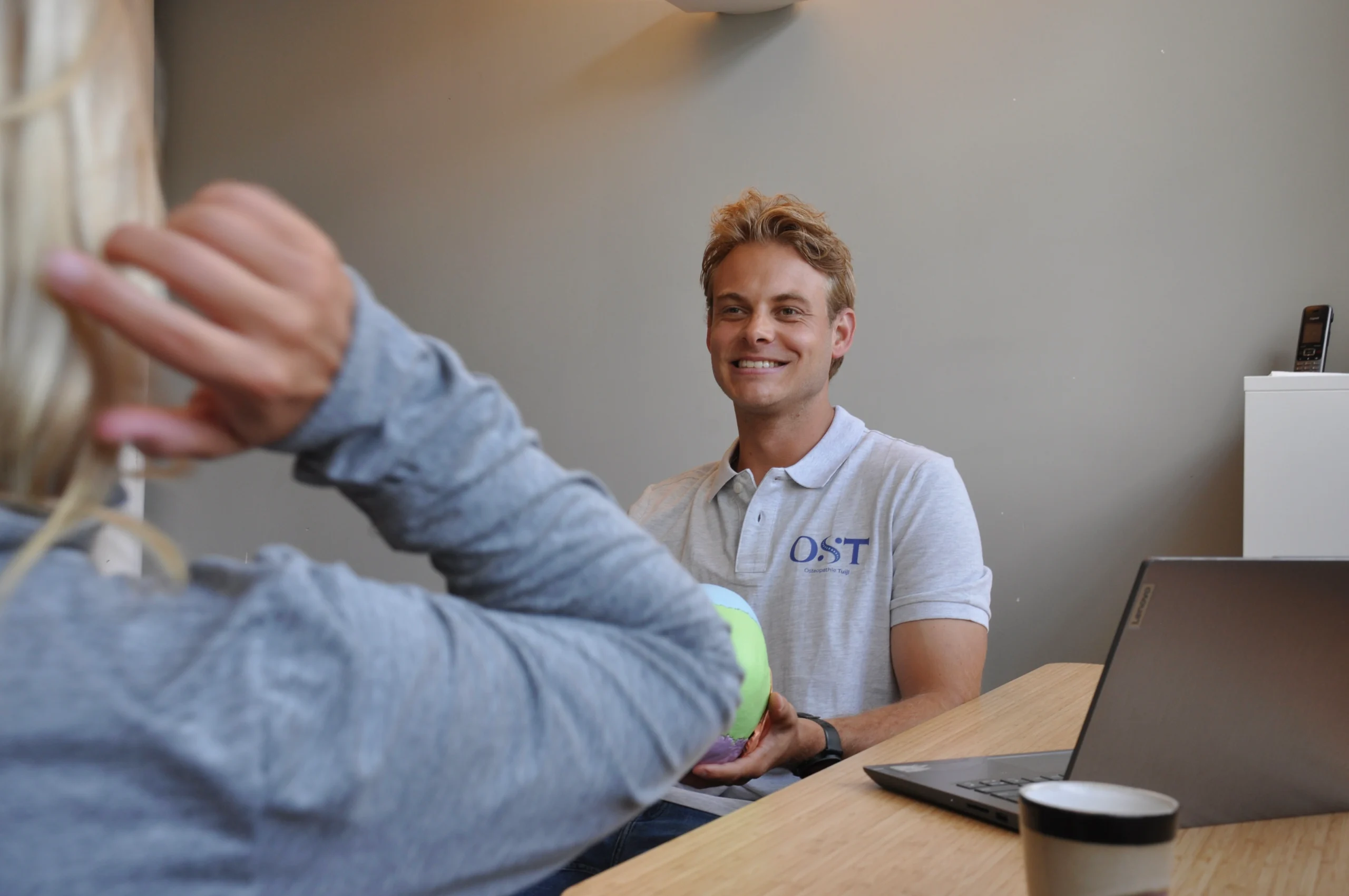 Osteopaat in gesprek met patiënt tijdens consult in praktijk Osteopathie Tuijl