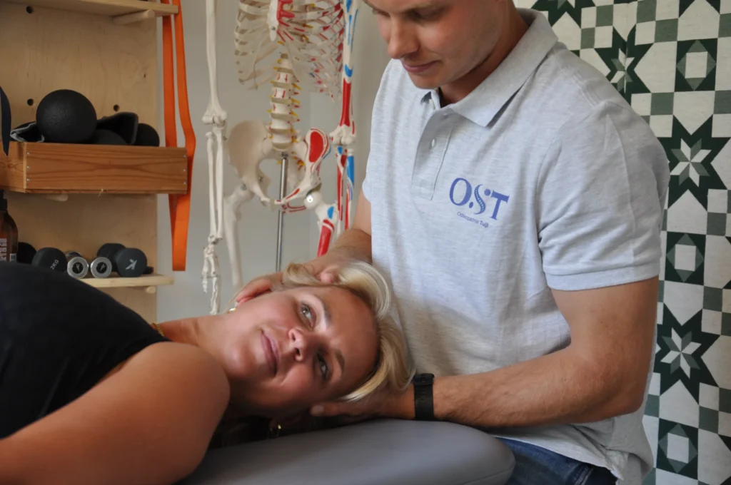 Osteopaat behandelt patiënt met nekmanipulatie in praktijkruimte met skeletmodel en oefenmateriaal